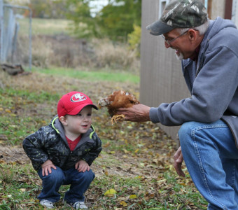 Grandpa Bernie and Cooper with a young chicken