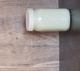 Fresh, raw goat milk in a quart glass jar