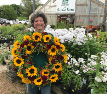 Karen holding wreath of sunflowers