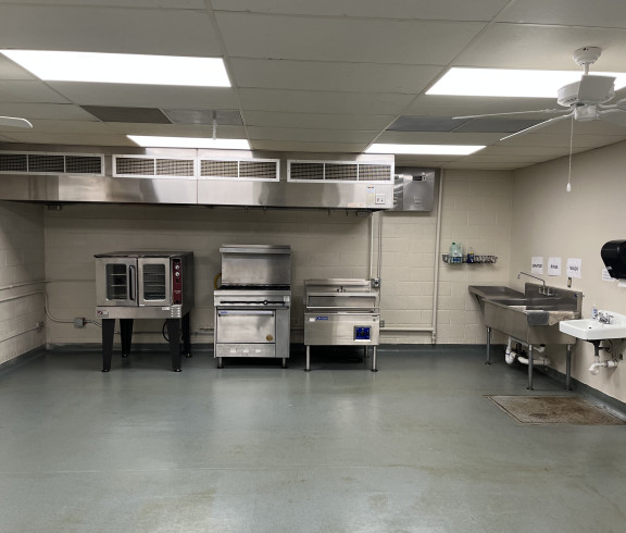 The Incubator Kitchen includes a six burner natural gas stove & oven, a large electric convection oven, a large electric tilt skillet, which are all located under a vent hood system